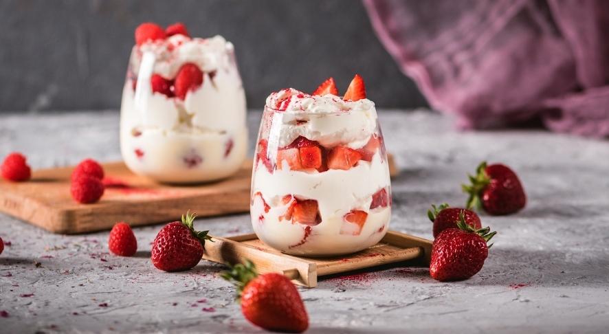 Whipped cream and strawberries in jar.